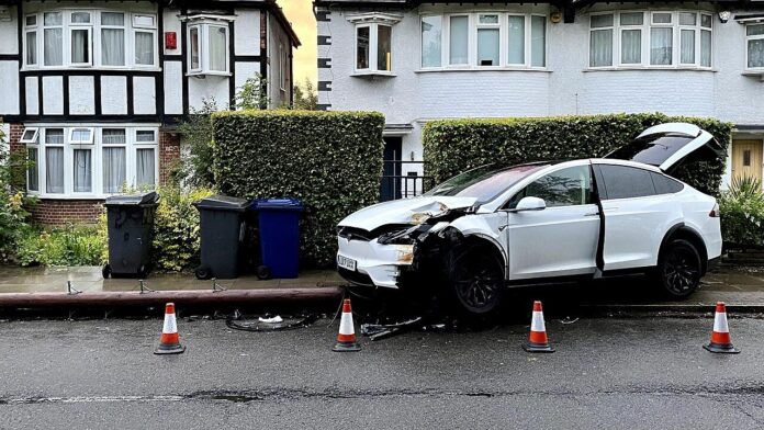 A crashed Tesla Model X with front-end damage on Nether Street in Finchley, London