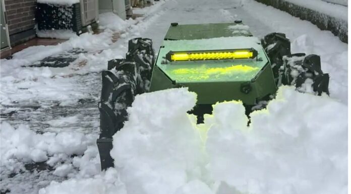 everblue Technologies' small electric snow removal drone pushing snow along a residential path