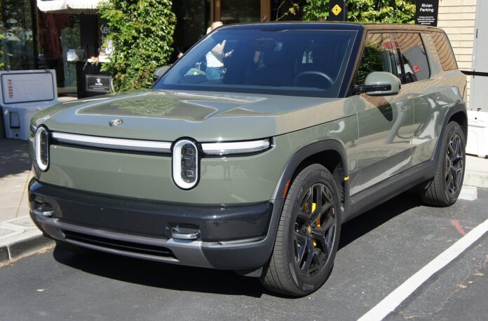 Green Rivian R2 SUV parked outside Rivian's store at Stanford Shopping Center in Palo Alto, California