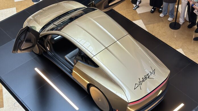 Gold Tesla Cybercab on display, seen from above Gold Tesla Cybercab on display with its butterfly doors open, seen from above (cropped)