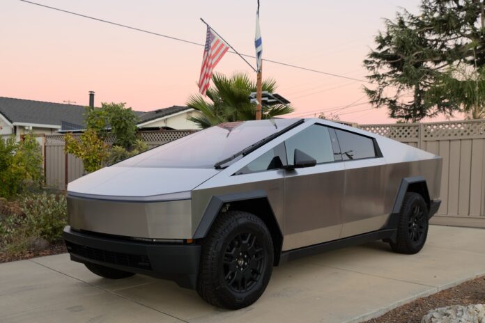 A stainless-steel Tesla Cybertruck Foundation Series parked in a driveway at dusk in San Jose, California (cropped)