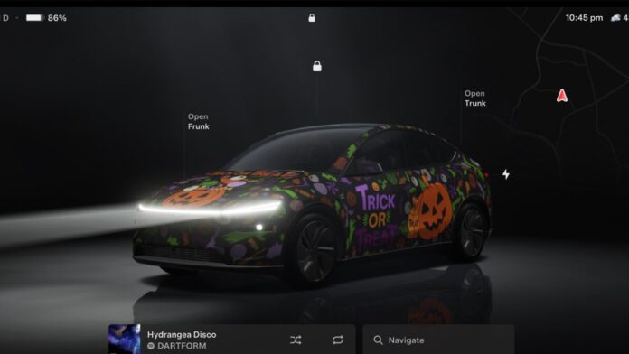 Tesla touchscreen showing a Model Y in Halloween Mode's orange and purple Trick or Treat wrap
