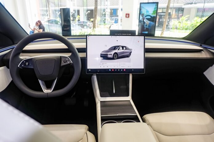 Interior of a Tesla Model Y L showing the central touchscreen where drivers use Grok