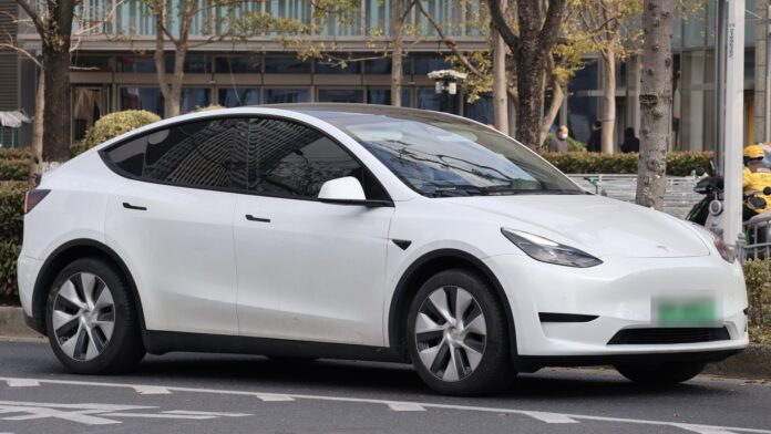 White Tesla Model Y on a Shanghai street White Tesla Model Y with green new-energy plates parked on a street in Shanghai, China